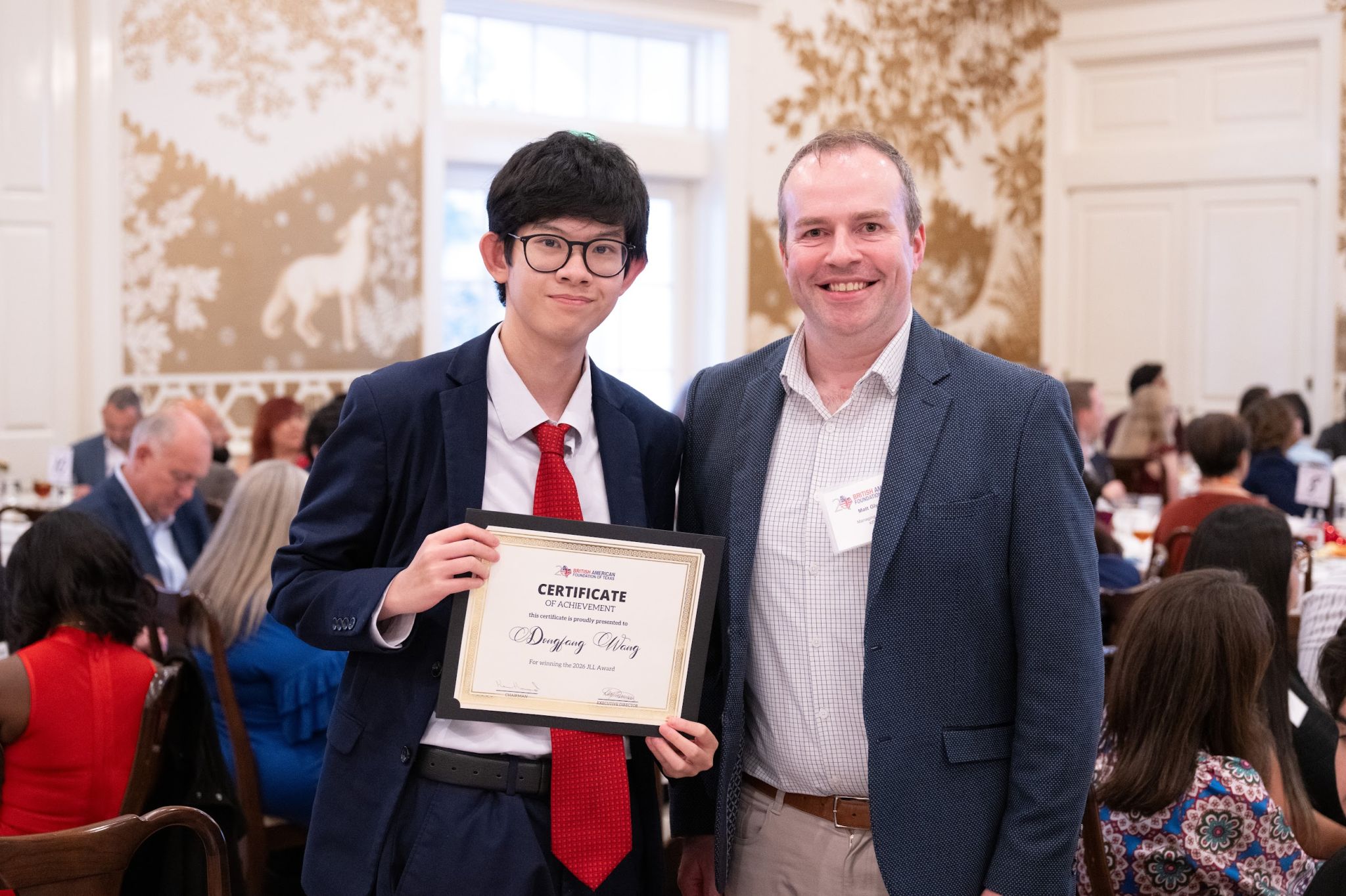 Dongfang holding his 2026 JLL Award certificate, with Matthew Glynn of KPMG US